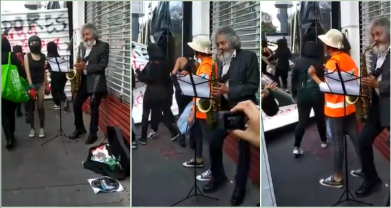 Sujeto toca su saxofón mientras encapuchadas destrozan y hacen pintas en marcha 8M (VIDEO)